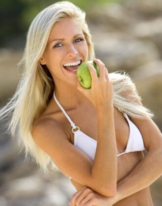 ένα κορίτσι τρώει ένα μήλο για απώλεια βάρους κατά 10 κιλά το μήνα